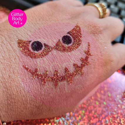 Pumpkin face glitter tatto created with moonshine glitter, stencil and body glue